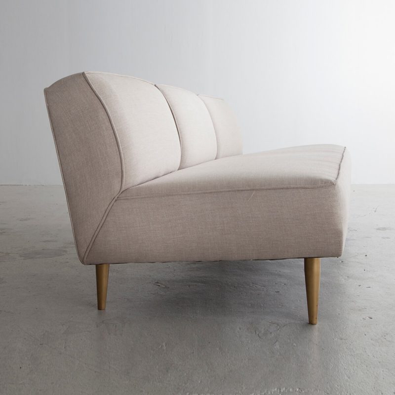 Three-seat sofa in white upholstery with tapered brass legs.