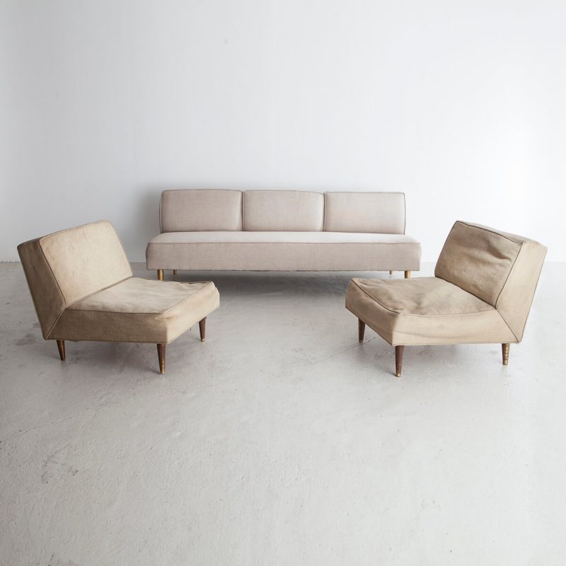 Three-seat sofa in white upholstery with tapered brass legs.